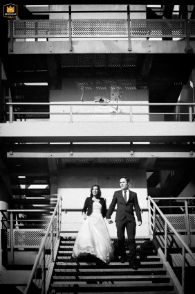 A wedding photographer captures a unique BW image at a Toulouse metro station. The image shows the newlywed couple descending the stairs, hand-in-hand, a portrait of their journey together.